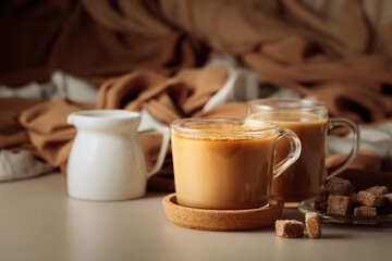 Latte with brown sugar on a beige background.