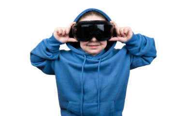 A young girl wearing a blue hooded sweatshirt holds a black VR/AR headset, smiling as she prepares to wear it. Shot against a transparent backdrop