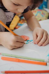 The boy draws with felt-tip pens