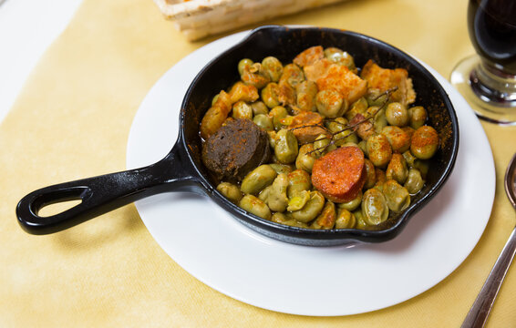 Traditional Catalan tapa of faba beans stewed with morcilla, chorizo and bacon served on frypan