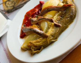 Typical serving of Catalan dish from grilled eggplant, onion and bell peppers (escalivada) with anchovies ..