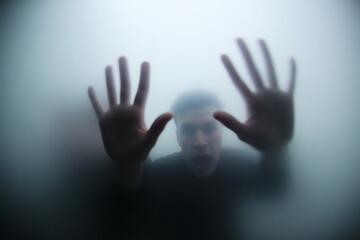ghostly figure behind misted window