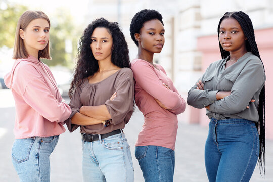 Multiracial group of millennial women in casual standing on the street, having strike. Pretty young multiethnic ladies protestors fighting for women rights. Feminism, womens equality day concept