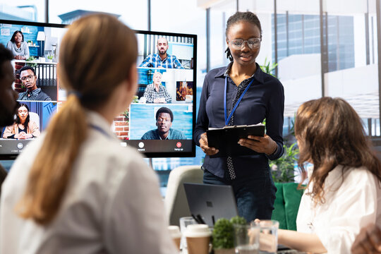 Diverse team of workers reviewing project updates together with shareholders on video call online meeting, ensuring easy remote collaboration for global business expansion plans. Teamwork.