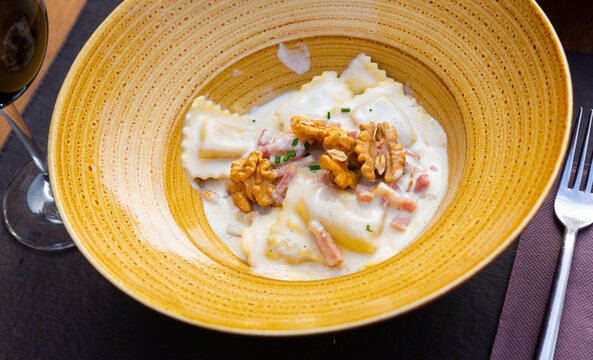 Goat cheese ravioli with carbonara sauce and walnuts