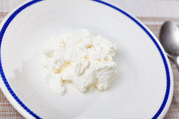 Fresh cow milk cottage cheese on plate ready to eat. Healthy nutritious food ..