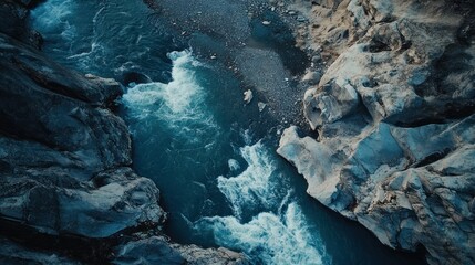Aerial view of a glacial river surging through a rocky gorge