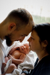 a candid photo of a young family and a long-awaited baby in their arms, selective focus, noise effect