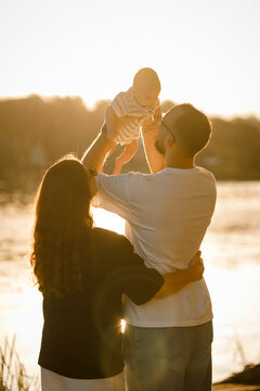 a candid photo of a young family and a long-awaited baby in their arms, selective focus, noise effect