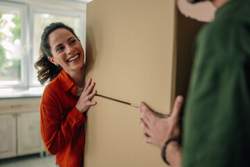 Couple moving refrigerator into new home having fun