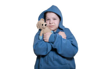 Sad worried child in blue hoodie hugging a teddy bear tightly, looking at camera. Isolated subject on transparent background