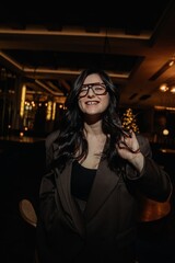 photo of a stylish brunette in glasses against the background of a restaurant interior with blurred...
