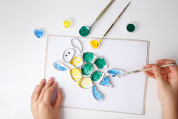 top down view of close up of hands painting activity, toilet paper roll rings turtle art idea, funny craft and DIY project for parents with children,