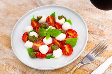National Italian snack is Caprese made from tomatoes, mozzarella, basil and Pesto sauce. Close-up image