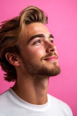 Fototapeta premium Elegant men's shoulder-length taper haircut - midlife white man with blond hair. A man with natural beauty and a confident stance. Pink solid background. Visual idea of style for aging men.