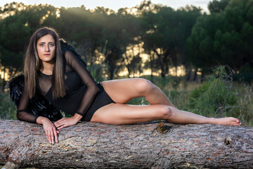 Woman in the forest posing with dark wings