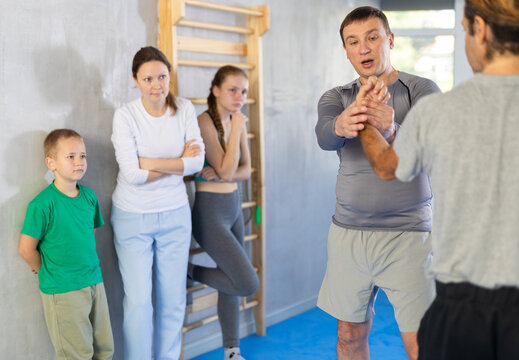 During classes and self-defense training, male teacher shows example and explains execution of painful process modus to neutralize enemy
