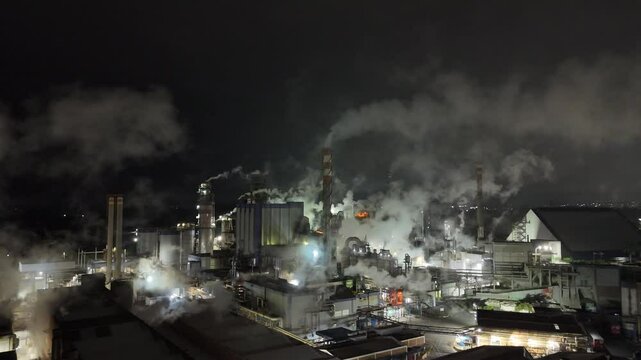 imagem a&eacute;rea noturna 4k de ind&uacute;stria de papel revela forte emiss&atilde;o de poluentes e vapores, simbolizando o impacto ambiental da produ&ccedil;&atilde;o em larga escala no setor fabril