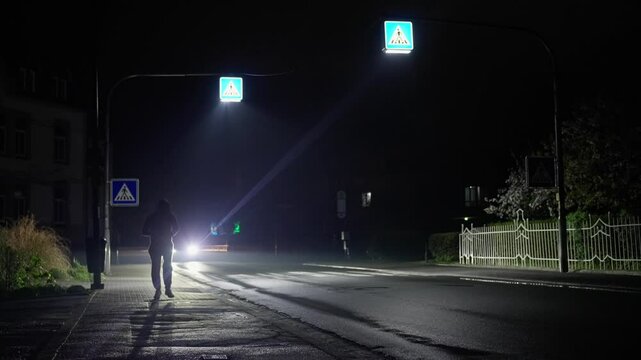 A man wearing rain rustler running on a street at night. Raining. front view recorded at 120 fps on cinema camera.