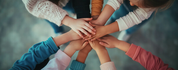 Group of children standing indoors and putting their hands together. Unity and teamwork concepts.