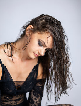 Young women posing with wet hair and black transparent bodysuit.