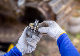 A service technician repairs a damaged hydraulic pump. Professional power hydraulics workshop. Hydraulic motor folding. Disassembly hydraulic piston pump, repair maintenance heavy machinery