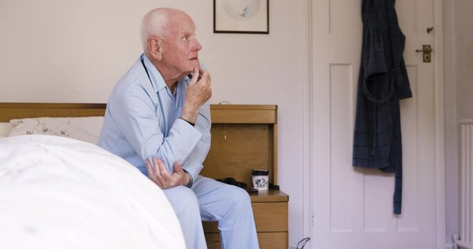 Thinking, morning and senior man in bed with mental problem, Alzheimers and dementia at home. Depression, retirement and worried elderly male sitting in bedroom with sadness, memories and confusion