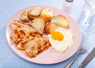 Fried pork fillet with scrambled eggs and french fries