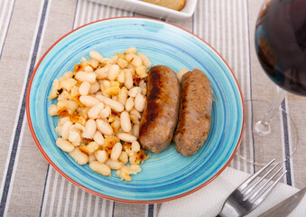 National Spanish dish of Catalan cuisine of fried pork sausage Butifarra, served with a side dish of fried white ..beans