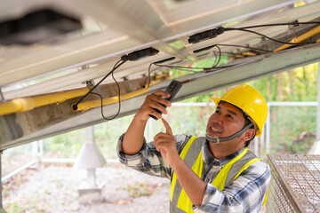 Solar Panel Inspection: An attentive inspector, equipped with a yellow hard hat, meticulously...