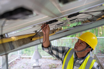 Solar Panel Technician: A focused technician meticulously inspects the wiring of a solar panel,...