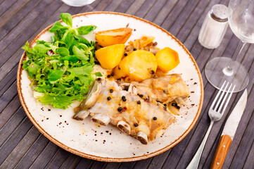 Delicious pork ribs with boiled potatoes and fresh salad leaves