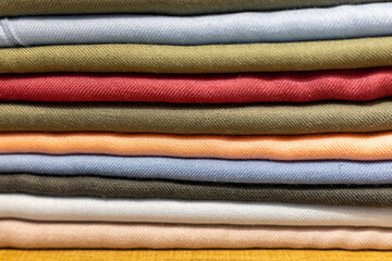 Colorful stack of neatly folded fabric showcasing various textures and hues in a home sewing space