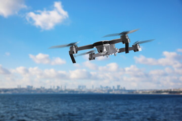Naklejka premium Drone with camera flying over sea. Unmanned aerial vehicle for surveillance