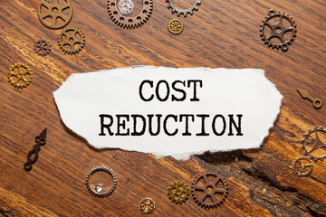 COST REDUCTION is written on a white tablet held by a man.