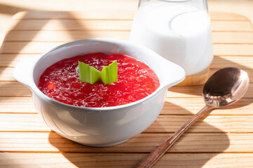 Red Dessert In White Bowl With Milk On Wooden Board