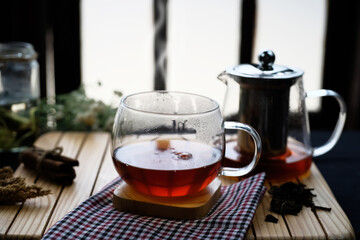 Warm Reddish Brown Tea In Glass Cup On Wooden Table