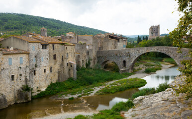 Obraz premium Medieval vaulted arch bridge over Orbieu river in Lagrasse, France..