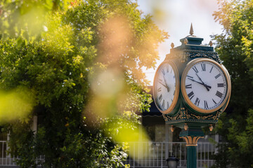 Los Altos, California, USA - August 30, 2024: Morning traffic passes the historic wrought iron clock in the historic downtown district.