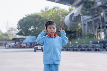 Happy little boy taking photos with airplane background at cafe