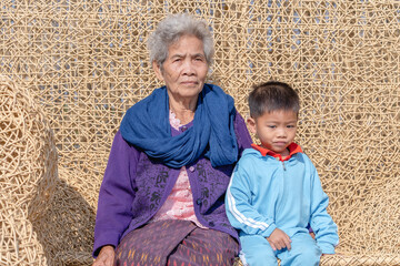 Grandmother and grandson in the cafe or farm, looking at camera, vacation and family concept