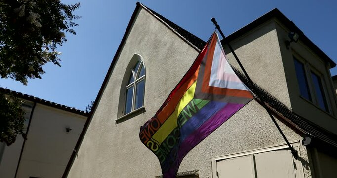 An inclusive pride flag blows in the wind outside of a historic church in Los Altos, California, USA.