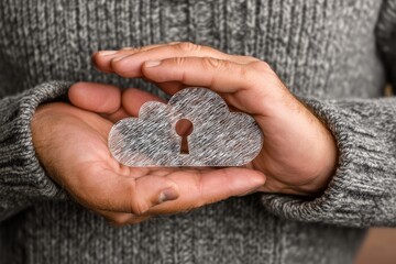 Obraz premium Hands holding a cloud-shaped lock symbolizing digital security.