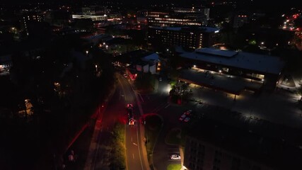 Aerial top down driving fire truck with red lights on street at night. American city with firemen during operation in the evening. Rising shot scene.