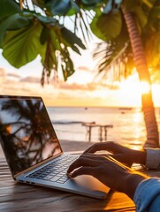 African adult using laptop on tropical beach during sunset.
