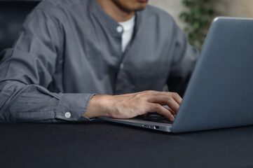 Focused Individual Working on Laptop in Modern Workspace Environment