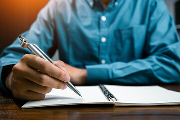 Male hand taking notes on the notepad. businessman working at work table, checklist writing...