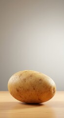 Fototapeta premium A Single Russet Potato on a Wooden Surface Against a Neutral Background, Simple Food Photography