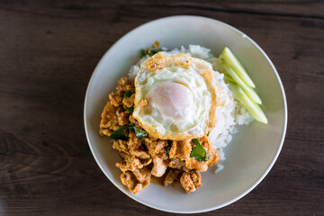 Stir fried pork with curry paste and fried egg on rice. Top view