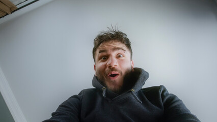Young Boy Reacting with Amazement While Unboxing a Package from a Low Angle Perspective